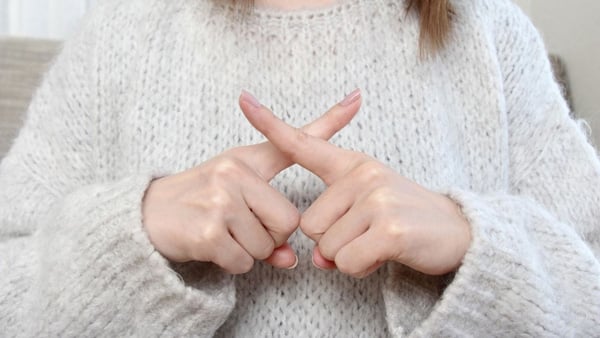 指でXを作る様子