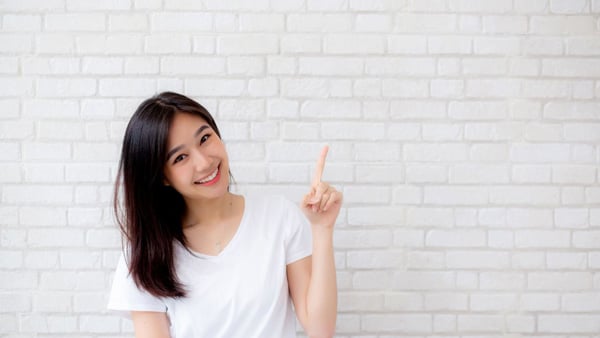 上を指さす女性