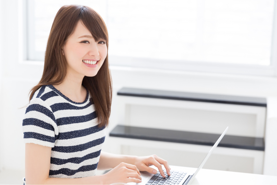 ノートパソコンを操作する女性の画像